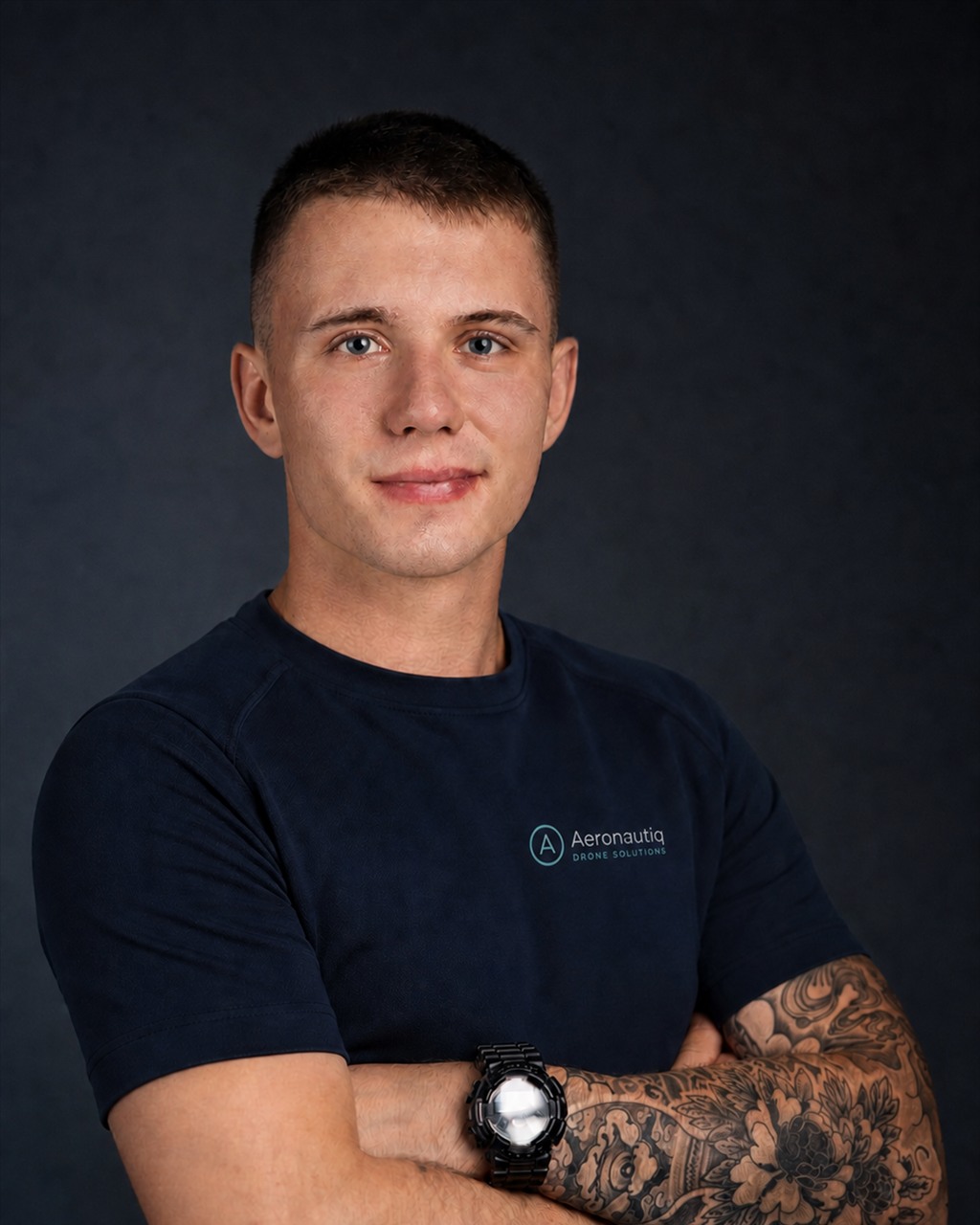 Retrato de Przemysław Żółkiewicz con una camiseta azul marino con el logotipo de Aeronautiq y los brazos cruzados